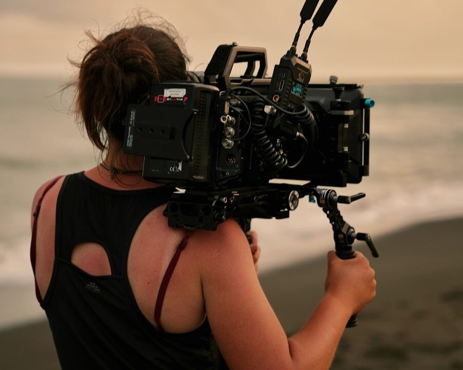 a woman with a camera on a beach